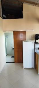 ein leeres Zimmer mit einem Kühlschrank und einer Tür in der Unterkunft Cantinho do Jorge in São Pedro da Aldeia