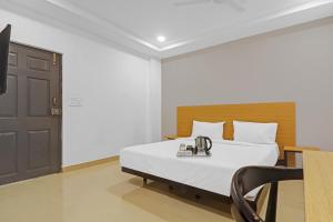 ein Schlafzimmer mit einem Bett und einem Telefon darauf in der Unterkunft Super Townhouse 862 Che Sigma in Hyderabad