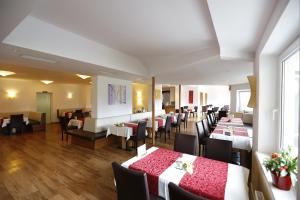 un restaurante con mesas y sillas en una habitación en Premium Wanderhotel Steirerhof, en Schladming