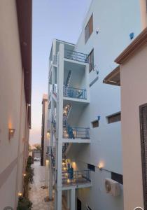 ein weißes Apartmenthaus mit einer Seitentreppe in der Unterkunft Sphinx in Hurghada