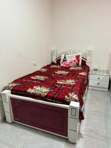 ein Bett in einem Schlafzimmer mit einer roten Decke drauf in der Unterkunft Sphinx in Hurghada