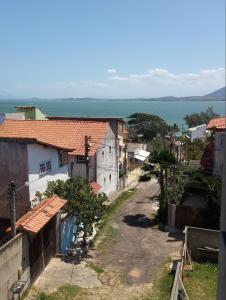 a view of a village with the ocean in the background at Cantinho da Sagrada família in São Pedro da Aldeia