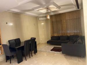 uma sala de estar com um sofá, uma mesa e cadeiras em Cosy Appart em Casablanca