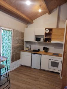 una pequeña cocina con electrodomésticos blancos y una mesa en Pleno Casco Vello, Céntrico, Reformado 2023, en Vigo