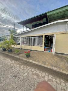 a building with a porch with potted plants on it at Hotel Mangueira in Paramaribo