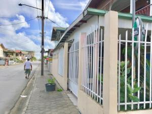 een man die in een straat naast een gebouw loopt bij Hotel Mangueira in Paramaribo