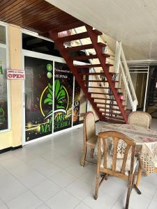 a table and chairs in a building with a staircase at Hotel Mangueira in Paramaribo