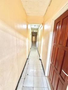 an empty hallway with a door and a tile floor at Hotel Mangueira in Paramaribo
