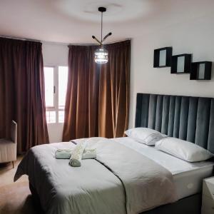- une chambre avec un grand lit et une grande fenêtre dans l'établissement NOUVEAU Appartement au plein centre ville en face Hilton M2, à Tanger