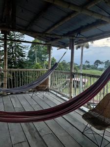 a hammock and chairs on a deck with a porch at Rancho Ventura in Filandia