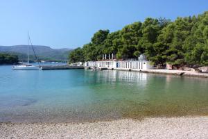 a body of water with a white building and a boat at Apartments by the sea Stari Grad, Hvar - 22052 in Stari Grad +14 photos