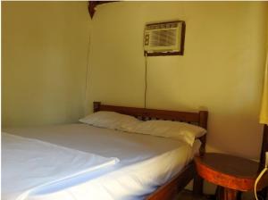 a bedroom with a bed with a fan and a table at La Choza Playa Venao in Playa Venao