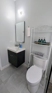a bathroom with a white toilet and a sink at Elegant Oasis by the Sea in Saint Annʼs Bay