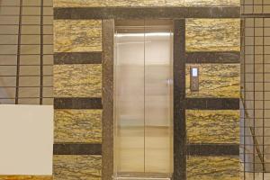 a elevator in a building with gold tile at Super Capital O Hotel Sai Balaji Near Golconda Fort in Hyderabad