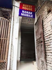 um sinal para uma casa de hóspedes perto de uma garagem em OYO Diamond Guest House em Rudrapur