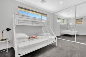 1 dormitorio con 2 literas y escritorio en 96C Esplanade, Semaphore, en Semaphore