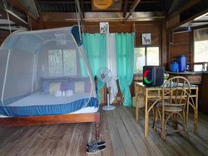 a bedroom with a bed and a table with a chair at Just Inn2 beachfront in El Nido
