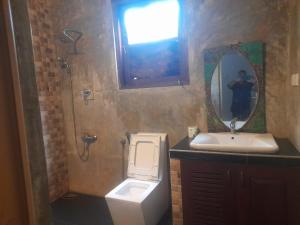 a bathroom with a toilet and a sink and a mirror at Sanuki Villa in Hikkaduwa +42 photos