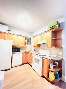 a kitchen with wooden cabinets and white appliances at O Canada Guest House in Toronto