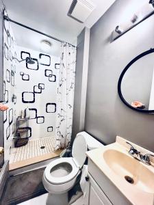 een badkamer met een toilet, een douche en een wastafel bij O Canada Guest House in Toronto