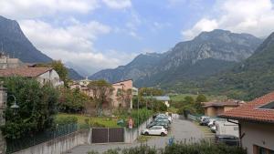 una ciudad con coches estacionados en un estacionamiento con montañas en 20 VENTI, en Angolo Terme