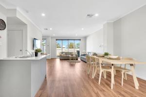 a kitchen and living room with a table and chairs at 96B Esplanade, Semaphore in Semaphore