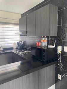 uma cozinha com um balcão preto e um micro-ondas em Apartamento en planta baja em Acapulco