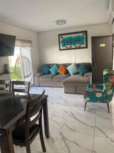 a living room with a couch and a table and chairs at Apartamento en planta baja in Acapulco +28 photos