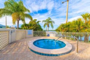 a hot tub in a patio with palm trees at Beautiful New Luxury Townhome with Private Beach and Swimming Pools in Ruskin