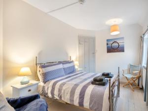 1 dormitorio con 1 cama con colcha a rayas en Manderley, en Sheringham