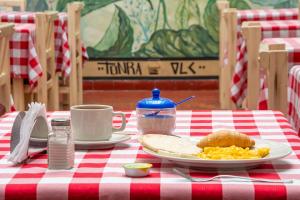 a red and white table with a plate of breakfast food at Hotel Ana Carolina in Manizales