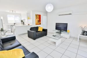 ein Wohnzimmer mit einem Sofa und einem TV in der Unterkunft 112 Olive Apartments in Mildura