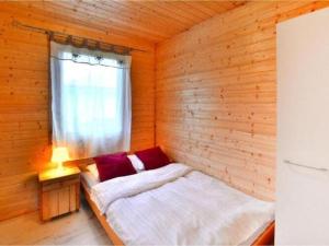 uma cama num quarto de madeira com uma janela em Single-story holiday house, Siano ty em Sianozety