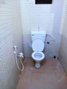 ein Badezimmer mit einem weißen WC in einer Kabine in der Unterkunft Hotel Madison Homes Bhubaneswar Near Lingaraj Temple and Ram Mandir in Bhubaneshwar