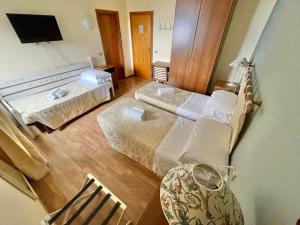 a room with two beds and a chair in it at Hotel Ristorante La Sorgente in Plesio