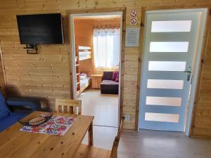 a living room with a table and a tv in a cabin at Cozy holiday home, Siano ty in Sianozety