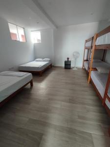 a room with three bunk beds and a wooden floor at BUNGALOWS CASAMAR in Tumbes