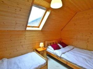 two beds in a log cabin with a window at Comfortable holiday cottages, Siano ty in Sianozety