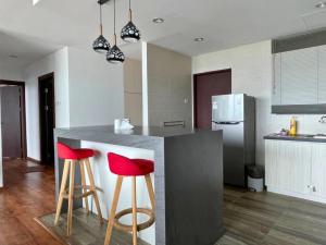 a kitchen with two red bar stools at a counter at DS VivacityMall Jazz Suite 3 810 in Kuching