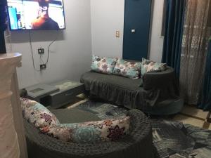 a living room with a couch and a chair at Babylon guesthouse in Aswan