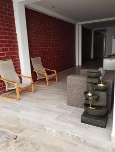 a patio with two chairs and a brick wall at BUNGALOWS CASAMAR in Tumbes