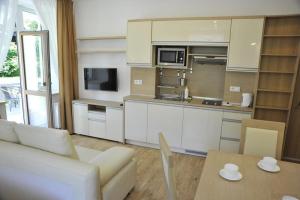 kuchnia i salon z kanapą i stołem w obiekcie Apartamenty Watra w Rabce