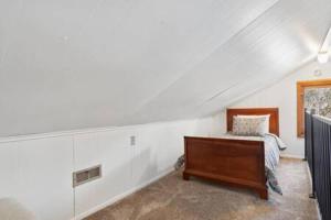 a attic room with a bed and a desk at Blue Spruce Cabin in Allenspark