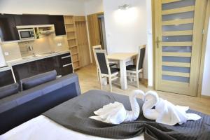 dwa łabędzie siedzące na łóżku w pokoju w obiekcie Apartamenty Watra w Rabce +37 zdjęć