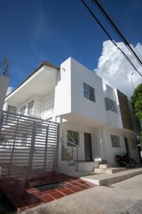 Biały dom z bramą przed nim w obiekcie APARTAMENTO VALLEDUPAR w mieście Valledupar