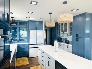 a blue kitchen with white counters and blue cabinets at Oahu's Best Kept Secret in Laie