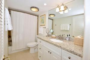 y baño con lavabo, aseo y espejo. en Royal Palm Penthouse #5, en Vero Beach