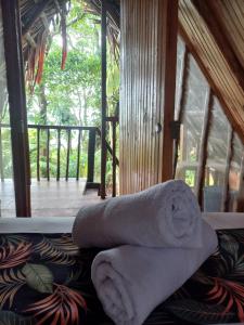 einen Stapel Handtücher auf einem Bett in einem Zimmer in der Unterkunft Cabañas Mangle House in Buenaventura