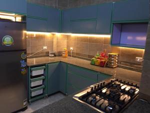 a kitchen with blue cabinets and a stove top oven at Babylon guesthouse in Aswan