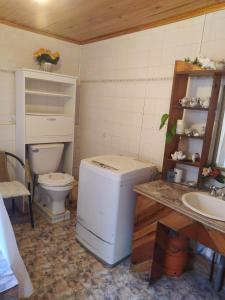 Baño pequeño con aseo y lavamanos en Casa habitacion condominio la Perla, en Isla Negra